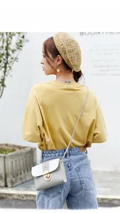 Détail du sac bandoulière élégant bicolore avec fermoir rotatif doré et clous