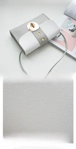 Gros plan sur cuir synthétique gris et blanc grainé avec boucle en métal doré