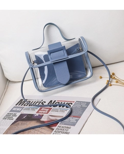 Blue transparent PVC crossbody bag with inner pouch on white sofa with flowers