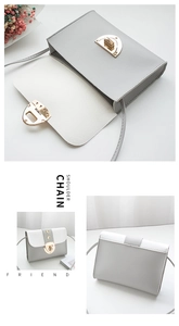 Détail du sac bandoulière gris et blanc avec fermoir demi-cercle doré et fine lanière