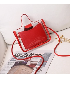 Detail view of transparent PVC handbag with red leather trim and matching inner pouch