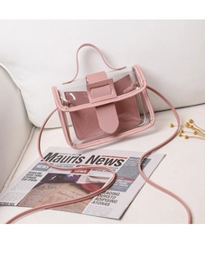 Detailed view of pink leather inner pouch and clear PVC crossbody bag on a white sofa
