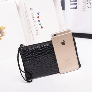Mini black crocodile pattern wristlet bag compared with iPhone for size reference