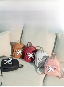 Detail of mini backpacks in five colors featuring bow ties and leaf-shaped zippers