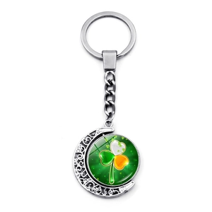 Vue détaillée du porte-clés lune argentée avec pendentif trèfle rotatif vert