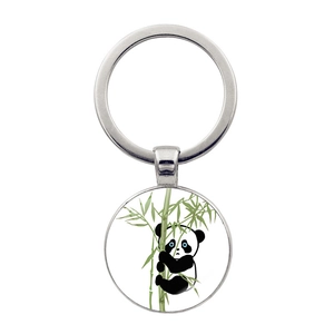 Detailed close-up of a round panda keychain with bamboo illustration and blue eyes