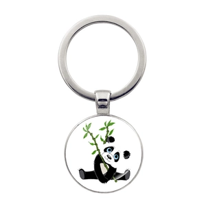 Close-up of a circular metal keychain with a cute panda holding bamboo illustration