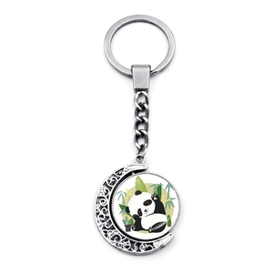 Gros plan du pendentif lune rotatif double face avec une illustration de panda mignon