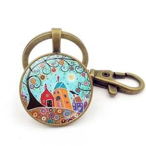 Détail de la peinture d'arbre et maison sous verre sur un porte-clés en bronze à fermoir