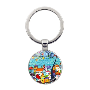 Macro detail of round metal keychain with abstract painted house and geometric art charm