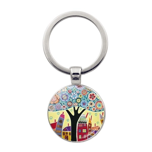 Detailed close-up of a round metal keychain pendant with colorful abstract tree and house art
