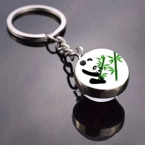 Close-up of a silver keychain with a round panda and bamboo glass dome pendant