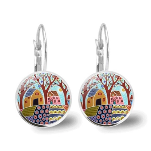 Detail of round leverback earrings featuring a folk art illustration of colorful houses