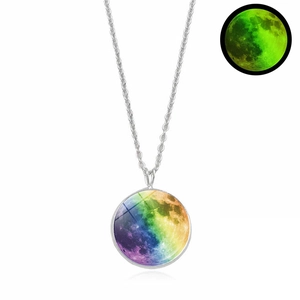 Close-up of luminous moon pendant necklace showing daytime colors and green night glow effect