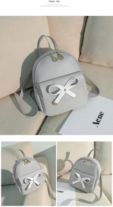 Detail of grey mini backpack with white bow decoration and leaf-shaped metal zipper pull