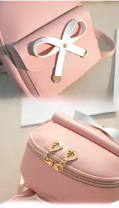Detailed view of pink backpack with white bow decoration and golden leaf-shaped zipper