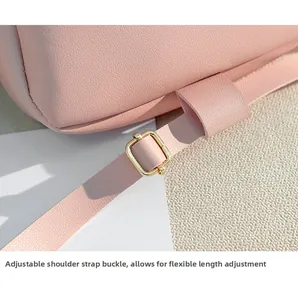 Detail of pink faux leather bag showing golden metal buckle on adjustable shoulder strap