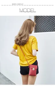 Présentation sur mannequin d'un petit sac à bandoulière rouge vertical avec boucle dorée