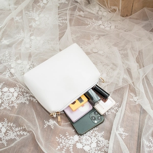 Sac bandoulière blanc minimaliste avec détails dorés montrant l'espace intérieur