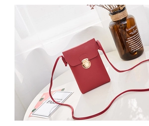 Détail du sac de téléphone vertical en similicuir rouge avec fermoir doré