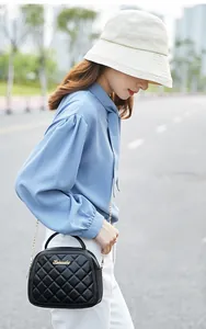 Chic black quilted crossbody bag with gold chain strap styled for a modern urban street look
