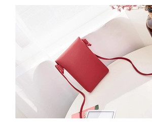 Petit sac de téléphone en cuir rouge grainé avec détail de nœud sur la bandoulière
