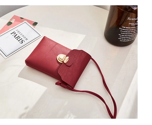Détail du mini sac à bandoulière rouge en similicuir avec fermoir en métal doré