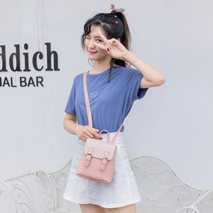 Mini sac à dos bicolore rose et crème avec boucles porté par un mannequin
