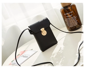 Détail du mini sac à bandoulière noir en similicuir texturé avec fermoir doré chic