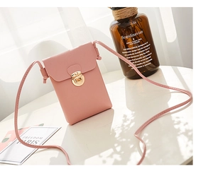 Gros plan détaillé du sac à téléphone en similicuir rose avec boucle dorée sur une table