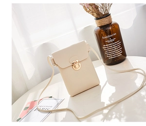 Détail de la pochette téléphone verticale crème avec fermoir doré et texture en similicuir