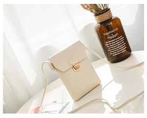 Détail du sac à téléphone vertical blanc crème avec boucle dorée et texture en cuir PU