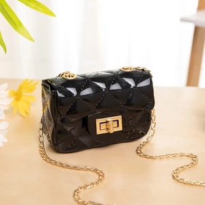 Mini quilted jelly bag with gold chain strap on a rustic wooden table background
