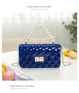 Close-up of royal blue quilted jelly bag featuring pearl handle and gold twist lock