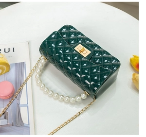 Detailed view of dark green quilted jelly bag with pearl handle and golden chain strap