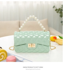 Detail of mint green quilted jelly bag with pearl handle and golden twist lock
