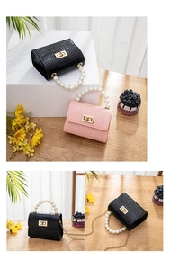 Detailed macro view of mini crocodile pattern bags in pink and black with pearl handle