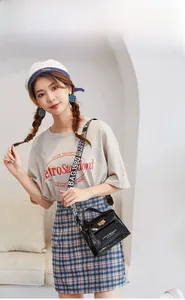 Chic black patent leather crossbody bag featuring Little Beauty text and wide woven strap