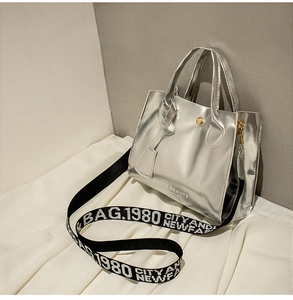 Détail du sac Kelly argenté brillant avec imprimé lettres et large bandoulière en tissu