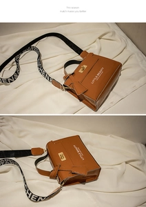 Detail of glossy brown mini bag with metal twist lock and wide patterned shoulder strap