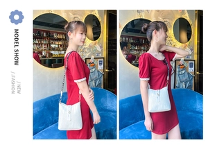 Detail of white crocodile pattern leather bucket bag with wide LOVE printed strap