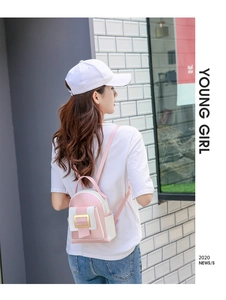 Détail mini sac à dos rose et blanc avec boucle dorée porté par un mannequin