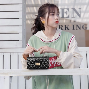 Quilted jelly crossbody bag with pearl handle and gold chain strap worn by a model