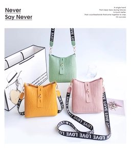 Detail view of colorful faux-crocodile texture bucket bags with branded LOVE wide straps