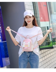 Détail du mini sac à dos en cuir rose avec boucle dorée et poche latérale contrastée