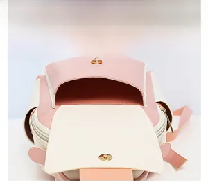 Détail du sac à dos en cuir rose et beige avec boucle magnétique et poche frontale