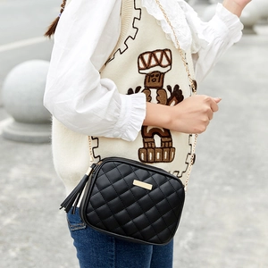 Black quilted crossbody bag with gold chain strap and stylish tassel detail