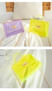 Detail view of colorful transparent PVC crossbody bags with golden chain straps and metal twist locks