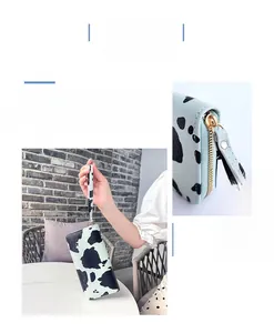 Close-up of cow print long wallet with textured finish and gold zipper detail