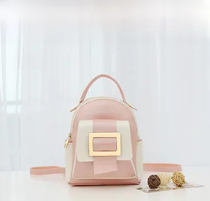 Détail du mini sac à dos rose et beige avec boucle dorée et poignée en cuir
